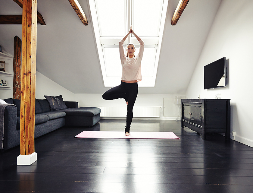Frau macht Yoga-Übung daheim