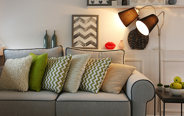 Gemütliches Sofa mit bunten Kissen und Stehlampe