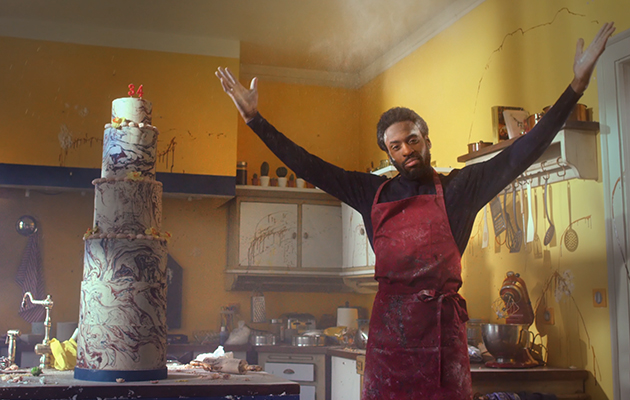 TV-Spot: Mann mit Mehlstaub in der Küche neben großer Torte